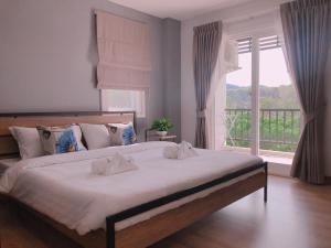 a bedroom with a large bed with a large window at Living at Sphere Apartment in Ao Nang Beach