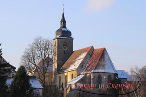 Une église avec une tour avec une horloge. dans l'établissement Ferien in Creußen, à Creußen