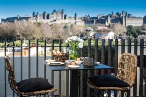 un tavolo con un vaso di fiori sul balcone di Sur le quai a Carcassonne