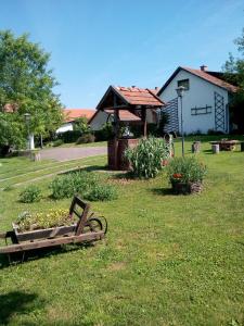 a park bench in the grass in front of a house at Kiad-lak apartmanok in Abádszalók