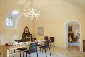 a dining room with a table and chairs and a chandelier at Agrigturismo Monte Cicogna in Moniga