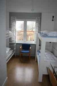 a small room with a bed and a window at Møn Hostel & Vandrehjem in Borre