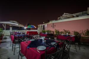 un grupo de mesas y sillas con manteles rojos en The Suncourt Hotel Yatri en Nueva Delhi