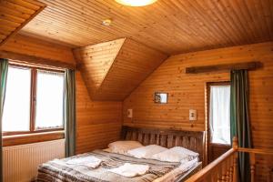 een slaapkamer met een bed in een houten hut bij Na Penkah in Jaremtsje +93 foto's