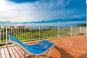 a blue chair sitting on the deck of a balcony at Apartment Fortuna in Cavtat