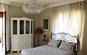a bedroom with a bed and a chandelier at Residenza Carlo di Borbone in Caserta