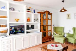 ネルハにあるCoronado 127 Apartments Casasolの白いキャビネット内のリビングルーム(テレビ付)