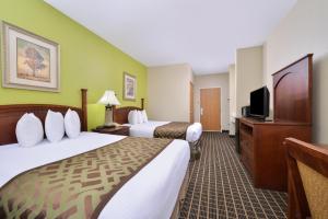 a hotel room with two beds and a flat screen tv at Regency Inn Geneseo IL in Geneseo