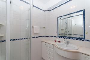 a white bathroom with a sink and a shower at Grace Villa in Aldeia de Juso