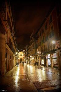 an empty city street at night with people walking down the street at ThePlacetoBe B&B in Valladolid