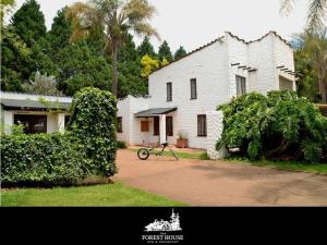 una motocicleta está estacionada frente a una casa en Forest House B&B en Harding