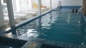 a swimming pool with chairs and a slide in the water at Hotel Palace Piriápolis in Piriápolis