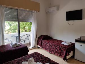 a hotel room with two beds and a balcony at Hotel Palace Piriápolis in Piriápolis