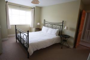 a bedroom with a black bed and a window at Glen Ard Holiday Home No 1 in Dunmore East