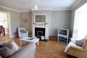 a living room with a couch and a table and a tv at Glen Ard Holiday Home No 1 in Dunmore East
