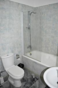 een badkamer met een toilet, een bad en een wastafel bij Argaka 1 Bedroom Apartment - Private Heated Jacuzzi - Large Communal Pool in Argaka
