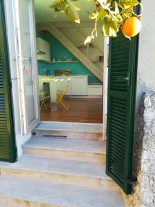 eine offene Tür, die zu einer Küche mit einem Orangenbaum führt in der Unterkunft Sant’Antonio in Finale Ligure