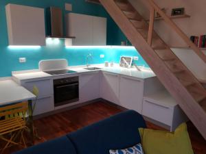 a kitchen with white cabinets and a blue wall at Sant’Antonio in Finale Ligure