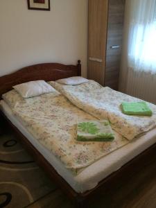 a bed with two green towels on top of it at Márti Vendégház in Hegykő