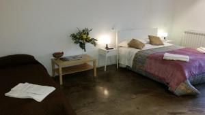 Un dormitorio con una cama y una mesa con un jarrón de flores. en Palermo Rooms, en Palermo