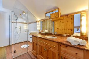 a bathroom with a sink and a glass shower at Landgasthof zum Erdinger Weissbräu in Rosenheim