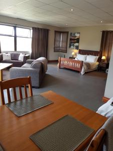 Stay@67 Apartments - Dullstroom في دولستروم: غرفة معيشة مع أريكة وسرير