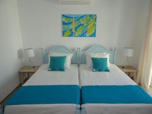 カバナス・デ・タビラにあるPetit Poissonのベッドルーム1室(青と白のベッド、ランプ2つ付)