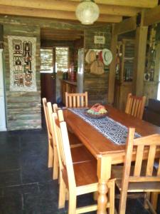 comedor con mesa de madera y sillas en Refugio de las Sierras en Villa General Belgrano