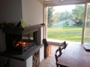a living room with a fireplace and a table and a window at La Davana Parma in Salsomaggiore Terme