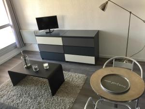 uma sala de estar com uma cómoda a preto e branco em Plage des Minimes Résidence Clarines em La Rochelle