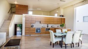 cocina y comedor con mesa y sillas en Luxury Bay View Villa 20 Right On Τhe Beach en Protaras