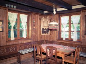 a dining room with a table and chairs and windows at Maison alsacienne in Eschau