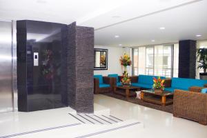un vestíbulo de un hotel con sofá azul y sillas en Hotel Andino en Bucaramanga
