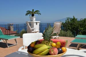 een fruitschaal op een tafel op een patio bij LA FENICE -white house- homeinsorrento- in Massa Lubrense