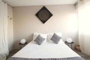 a bedroom with a white bed with two side tables at Mon Appart A GERLAND II in Lyon