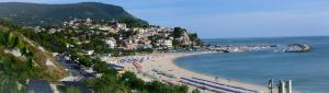 a beach with umbrellas and people on the sand at Affittacamere Caletta del Conero in Numana