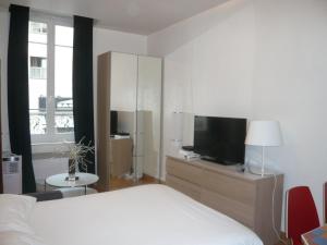 a bedroom with a bed and a tv on a dresser at Bridgestreet Le Marais - les halles in Paris