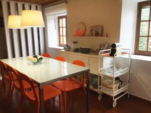 una cocina con mesa y algunas sillas naranjas en Casal dos Melros, en Cruzes 17 fotos más