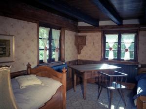 a bedroom with a bed and a table and windows at Maison alsacienne in Eschau