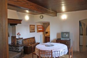 een woonkamer met een tafel en een televisie bij Appartamenti La Tartufaia Country house pool and relax By Gardadomusmea in Tremosine Sul Garda
