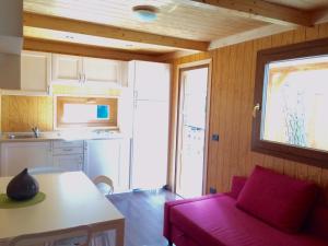 a living room with a red couch and a kitchen at Tigullio Camping & Resort in Sestri Levante