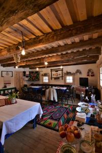 una sala de estar con mesas y sillas y un comedor. en Iz de Maramures Rural Hotel en Şurdeşti