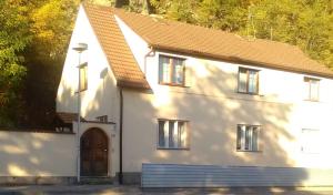 una pequeña casa blanca con techo marrón en Penzion Marjánka, en Hluboká nad Vltavou