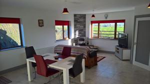 a living room with a table and chairs and a television at Doolin Heights Apartment in Doolin