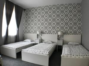 ヴロツワフにあるCityAparts - Rynek View 2 Bedrooms Private Apartment - FVのベッドルーム1室(ベッド2台付)が備わります。壁紙を用いた内装です。