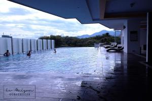 a swimming pool with people in the water at Le Maison GuestHouse @ Majestic Imperial in Ipoh