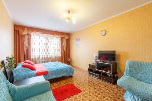 トゥーラにあるFlat Comfort on Zamochnaya 105Bのベッドとテレビが備わるホテルルームです。