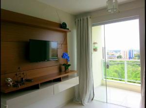 a living room with a flat screen tv on a wall at Atrium Thermas - Caldas Novas in Caldas Novas