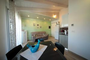 un soggiorno con tavolo in vetro e una cucina di Suite delle Rondini Apartment ad Alghero