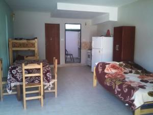 Habitación con cama, mesa y nevera. en Lo del Ruso en Las Grutas